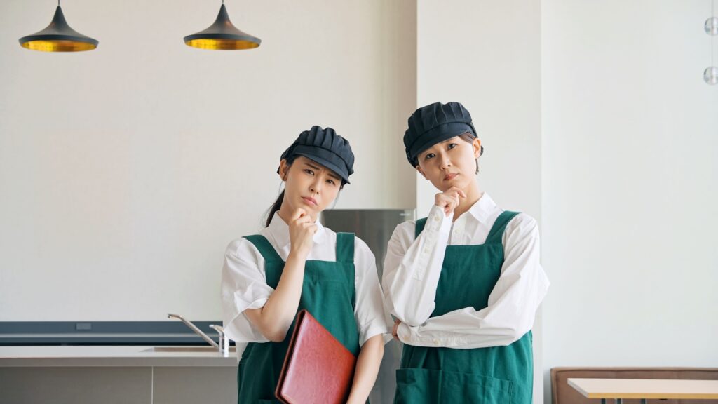 店内で悩む飲食店店員